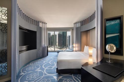 a hotel room with a bed and a large window at W Doha in Doha