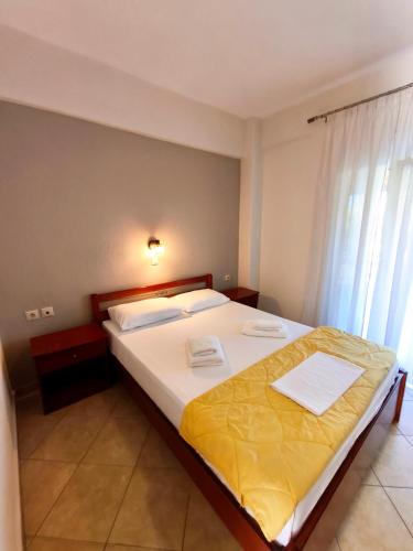 a bedroom with a large bed with yellow sheets at Kiparissis Apartments in Kriopigi