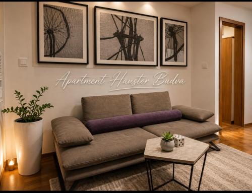 a living room with a couch and pictures on the wall at Budva apartman Haustor in Budva