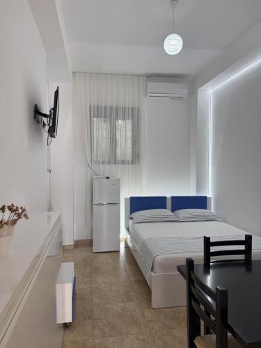 a bedroom with a bed and a table in it at Vila Kalluci in Borsh