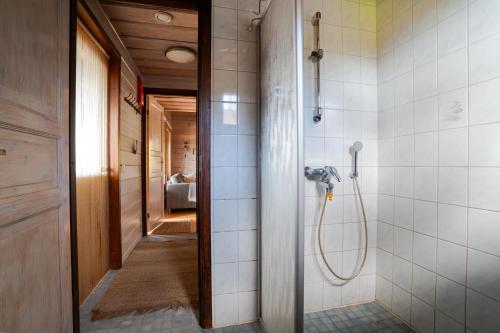 a walk in shower in a bathroom with white tiles at Villa Alli in Siikainen