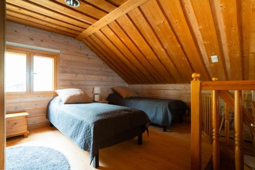a bedroom with two beds in a wooden cabin at Villa Alli in Siikainen
