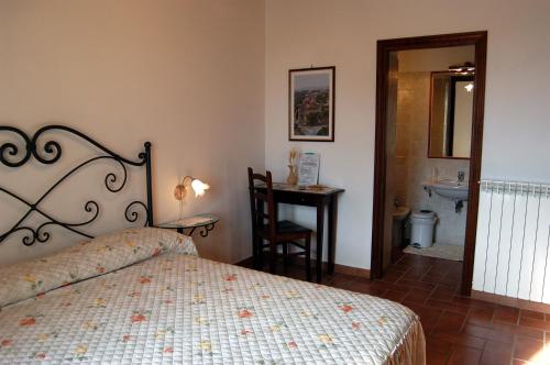 1 dormitorio con 1 cama y baño con lavamanos en Agriturismo Sovanella en Sovana