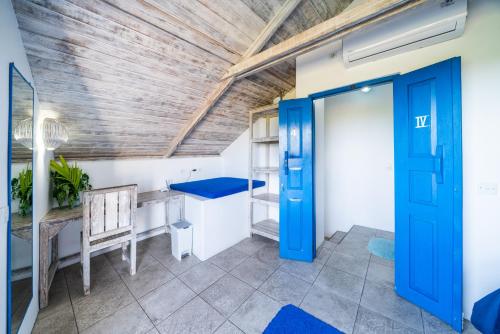 a room with a blue door and a wooden ceiling at Bali Bio Villas in Uluwatu