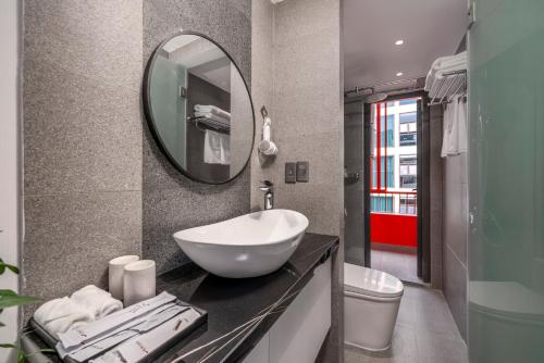 a bathroom with a sink and a mirror at The Locals Hotel - Dinh Thi Hoa Da Nang in Danang