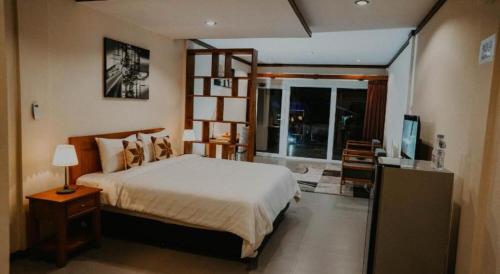 a bedroom with a bed and a television in it at Cozzy Seaview Beach Resort in Jepara