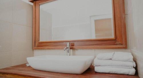 a bathroom with a sink and a mirror and towels at Cozzy Seaview Beach Resort in Jepara