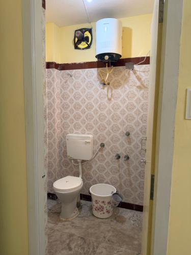 a small bathroom with a toilet and a sink at Villa Yogalakshmi in Chidambaram