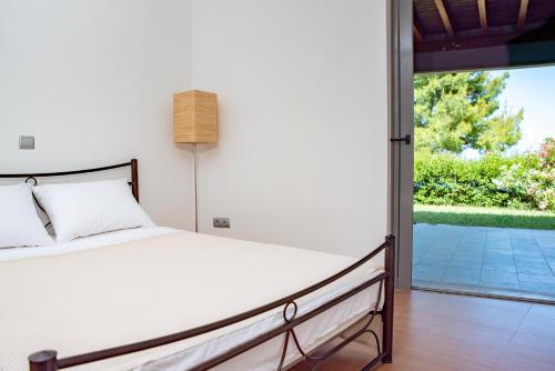 a bedroom with a bed and a sliding glass door at The Quite Blue villa in Kriopigi