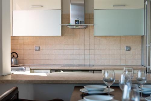 a kitchen with plates and wine glasses on a table at The Quite Blue villa in Kriopigi