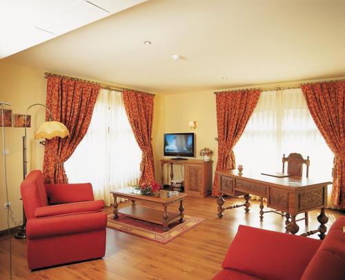 a living room with a red couch and a table at Palacio Azcárate Hotel in Ezcaray