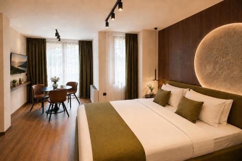 a hotel room with a large bed and a table at NOCE Luxury Apartments in Ohrid