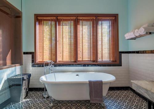 a bath tub in a bathroom with a window at Le Relais de Chhlong in Chhlong