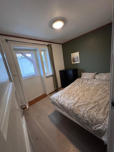 a bedroom with a bed and a window at Rent Apartament Lofoten in Svolvær