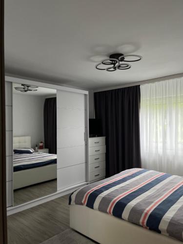 a bedroom with a bed and a dresser at Cazare Sandy in Novaci-Străini
