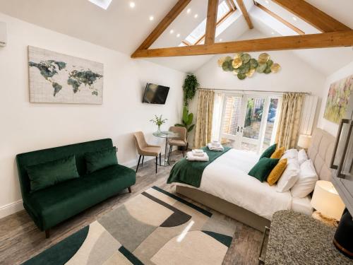 a bedroom with a large bed and a green couch at The Garden Hideaway Central Corbridge in Corbridge