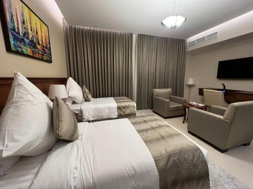 a hotel room with a bed and a living room at فندق الضليعة in Unayzah