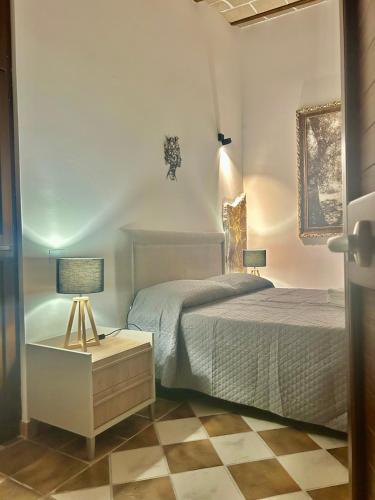 a bedroom with a bed and a table with a lamp at Krimar Hotel in San Vito lo Capo