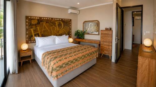 a bedroom with a large bed and a dresser at Amandalay Hotel & Villas in Karimunjawa