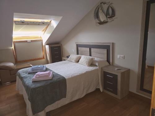 a bedroom with a bed with two towels on it at Mirador do Xistral in Valle de Oro