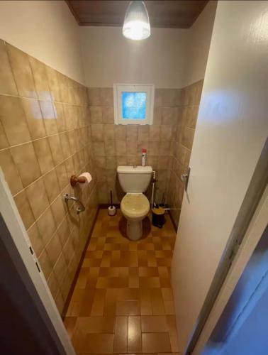 a small bathroom with a toilet and a window at Le logis d Adrien in Saint-Magne-de-Castillon