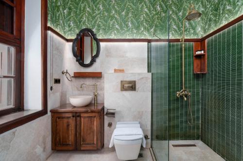 a bathroom with a shower and a toilet and a sink at Kalkan Port Hotel in Kaş