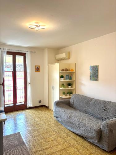 a living room with a gray couch in a living room at Casa Sponchie in Lazise