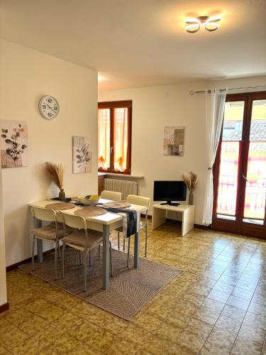 a living room with a table and chairs and a television at Casa Sponchie in Lazise