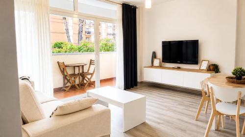 a living room with a couch and a tv and a table at Fenals Calm - con piscina in Lloret de Mar
