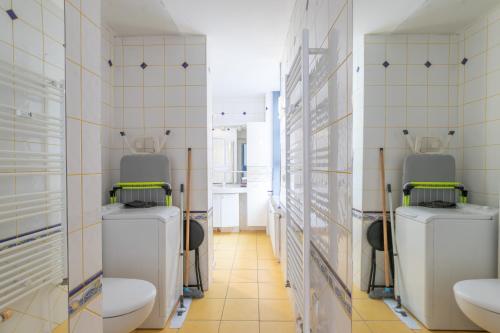 a bathroom with two toilets and two sinks at La Suite des Épinoches - Parking Privé in Mâcon
