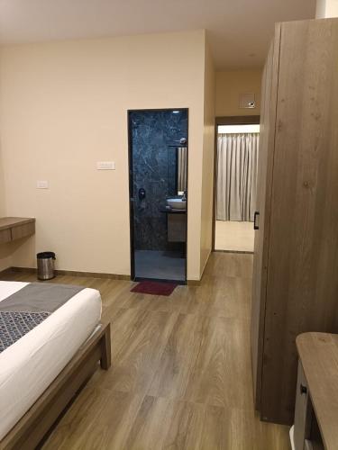 a room with a bed and a bathroom with a shower at Nicolas Farm & Resort in Mansar