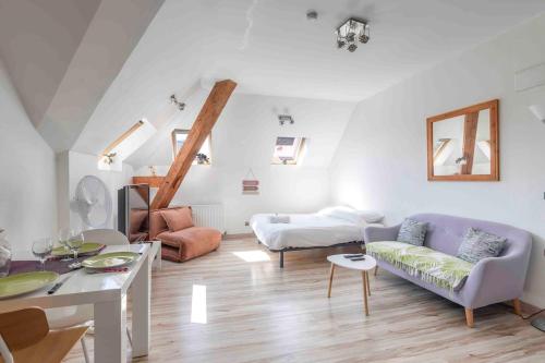 a living room with a couch and a table at La Suite des Épinoches - Parking Privé in Mâcon