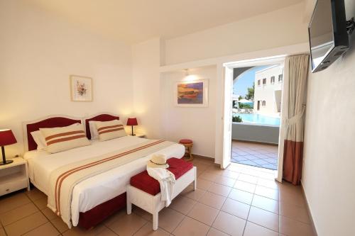 a bedroom with a large bed and a balcony at Nissia Traditional Residences Spetses in Spetses