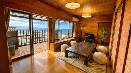 a room with a table and chairs and a balcony at Balistyle Tateyama View in Tateyama