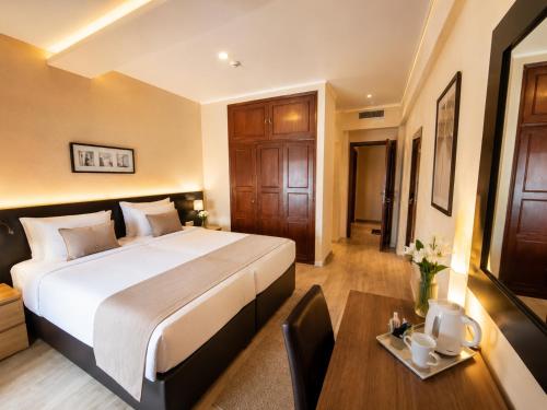 a hotel room with a large bed and a table at Hotel Riomar in Lagos