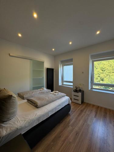 a bedroom with two beds and a large window at Casa del Mondo 1 in Sankt Aldegund