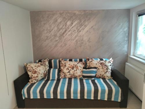 a couch with pillows on it in a room at Garsoniera 20m2 anexată la casa proprietarului in Botoşani