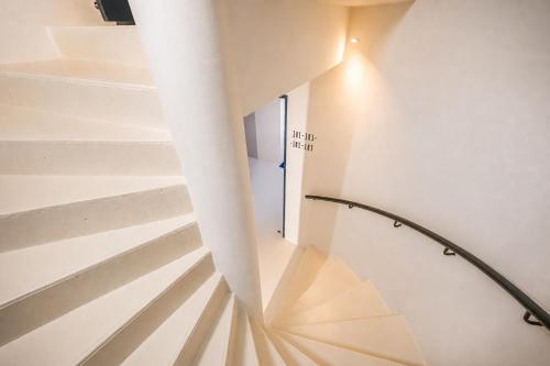 a spiral staircase in a house with a light shining on it at JIJI Suites Sénart in Combs-la-Ville