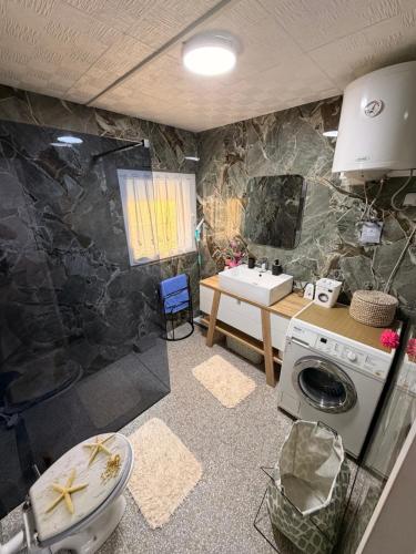 a bathroom with a sink and a washing machine at Vidikovac Cazin in Cazin