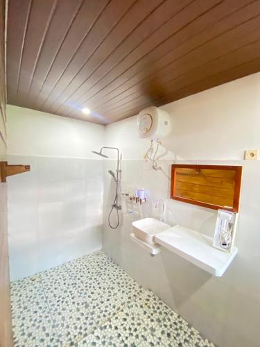 a bathroom with two sinks and a window at Forest Side Bungalow in Tetebatu