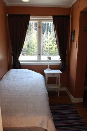 a bedroom with a bed and a window at Hen stasjon Venteværelset in Hen