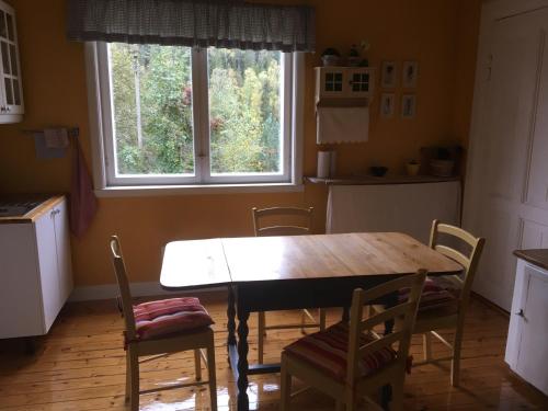 a kitchen with a table and chairs and a window at Hen stasjon Venteværelset in Hen