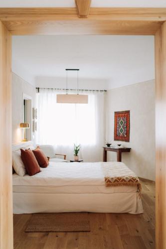 a bedroom with a large white bed and a window at Porumbacu134 in Porumbacu de Sus