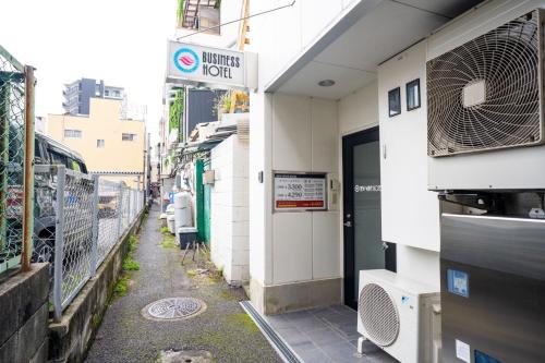 a narrow alley with a building with a sign on it at ホテル ニューウェーブ in Okayama