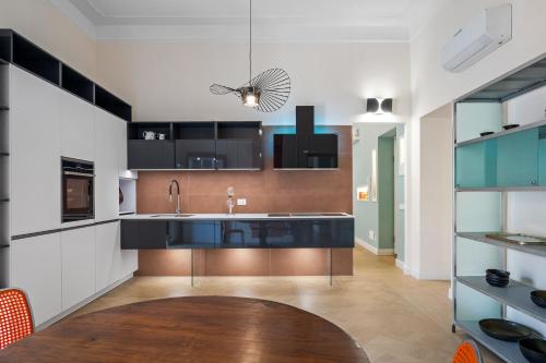 a kitchen with black and white cabinets and a sink at Borgogna Living in Vercelli