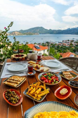 a table with plates of food on a table with a view at Les Terrasses De Selimiye in Selimiye