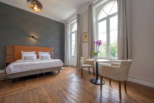 a bedroom with a bed and a desk and a table at Domaine du Béron - Chateau et gites in Cappelle-en-Pévèle