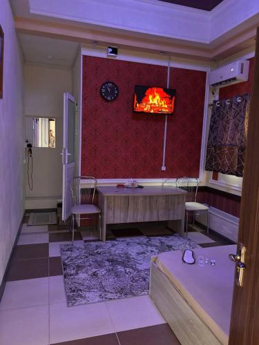 a living room with a fireplace and a table and chairs at Отель "VOSTOK" in Yalanghoch