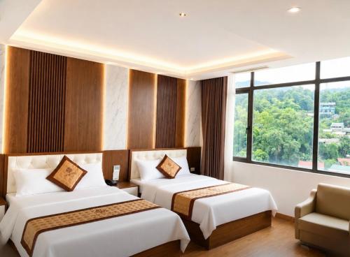 a hotel room with two beds and a window at Tv Hotel in Cao Bằng
