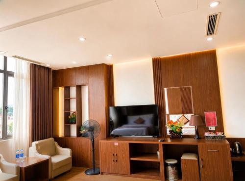 a living room with a television and a desk with a couch at Tv Hotel in Cao Bằng